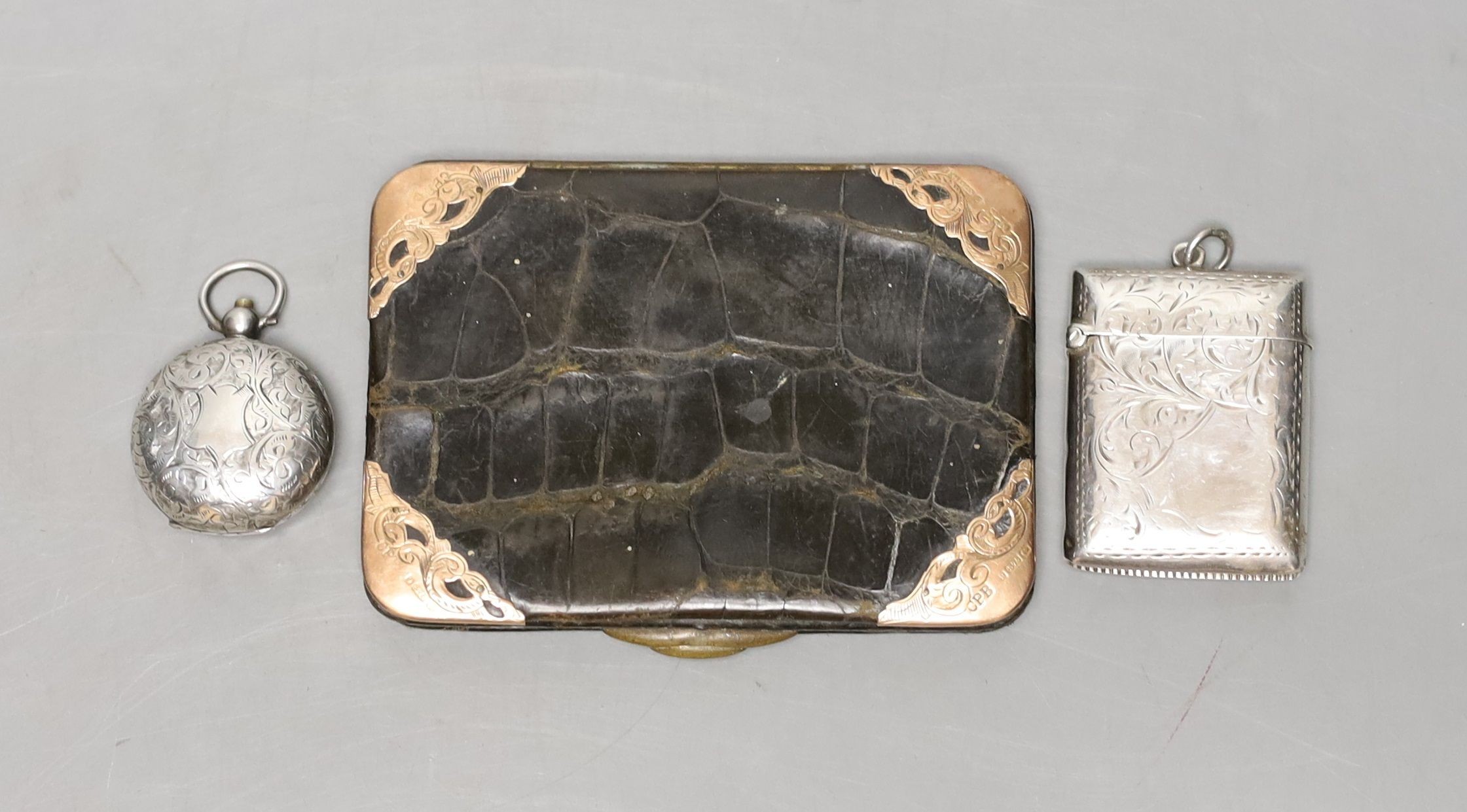 A late Victorian engraved silver sovereign case, a silver vesta case and an Edwardian 9ct gold mounted leather card purse.